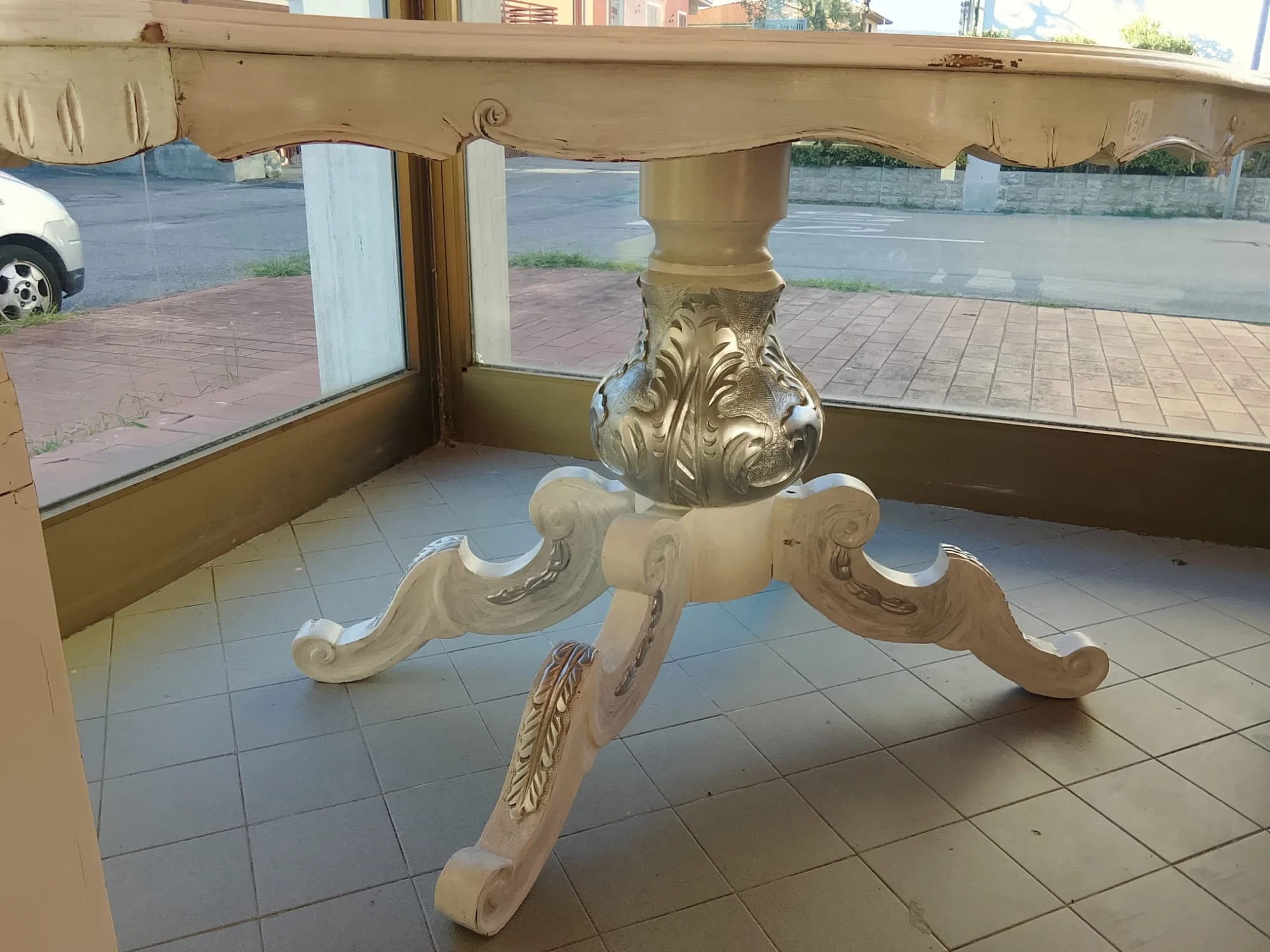 Dettaglio della base intagliata del tavolo ovale, con vaso a foglie d'acanto e quattro piedi a voluta