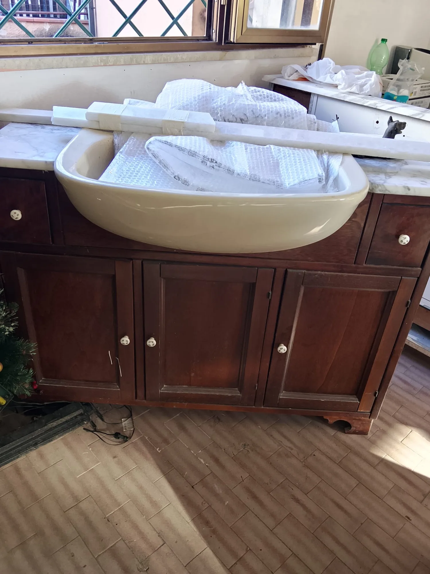 Mobile bagno in legno scuro con lavabo in ceramica e piani in marmo