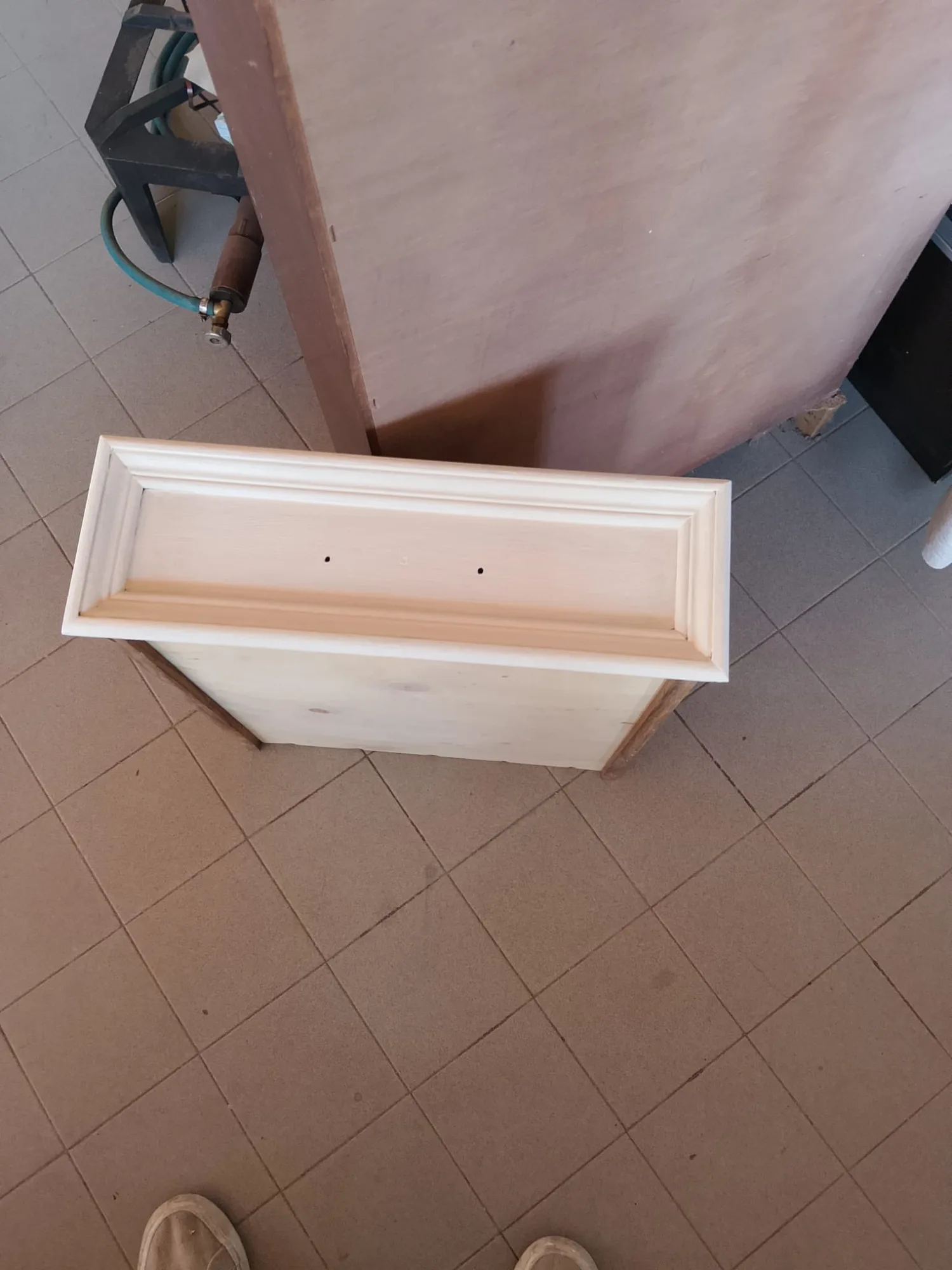 Mobiletto carteggiato in legno chiaro con cornice modanata, visto dall'alto