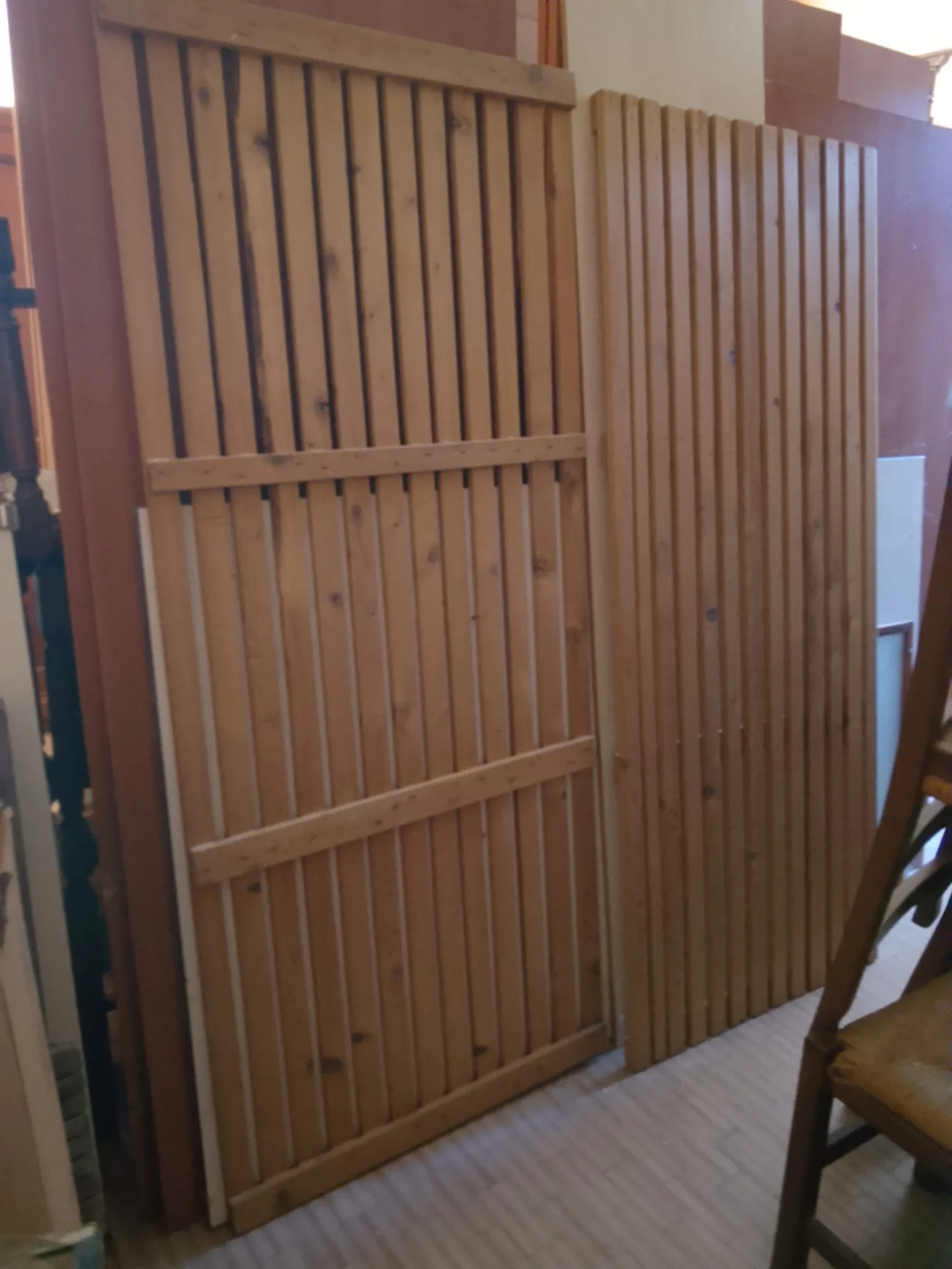 Reti a doghe in legno chiaro e listelli di ricambio appoggiati alla parete del magazzino